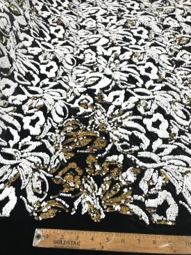 White/gold sequins flip two tone floral design on a black stretch velvet, Sold by the yard.